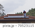 太陽光発電パネルを清掃する男性 70523115