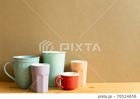 Many cups on wooden table with brown background 70524656