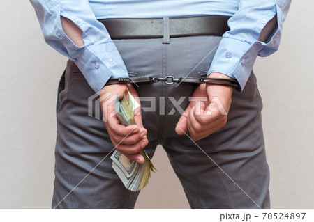 Corruption and bribery concept - arrested official with money in hands on white background Corruption and bribery concept - arrested official with money in hands on white background 70524897