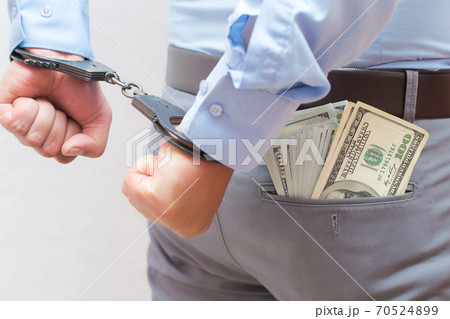 Corruption and bribery concept - arrested official with money in hands on white background Corruption and bribery concept - arrested official with money in hands on white background 70524899