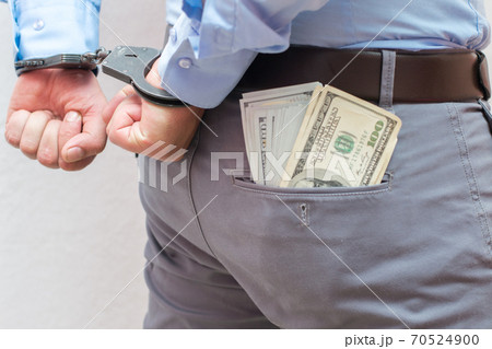 Corruption and bribery concept - arrested official with money in hands on white background Corruption and bribery concept - arrested official with money in hands on white background 70524900