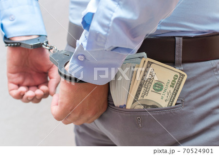 Corruption and bribery concept - arrested official with money in hands on white background Corruption and bribery concept - arrested official with money in hands on white background 70524901
