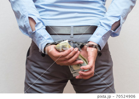 Corruption and bribery concept - arrested official with money in hands on white background	 70524906