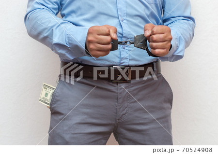 Corruption and bribery concept - arrested official with money in hands on white background Corruption and bribery concept - arrested official with money in hands on white background 70524908