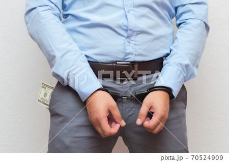 Corruption and bribery concept - arrested official with money in hands on white background	 70524909