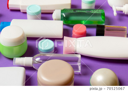 Top view of different cosmetic bottles and container for cosmetics on colored background. Flat lay composition with copy space Top view of different cosmetic bottles and container for cosmetics on colored background. Flat lay composition with copy space 70525067