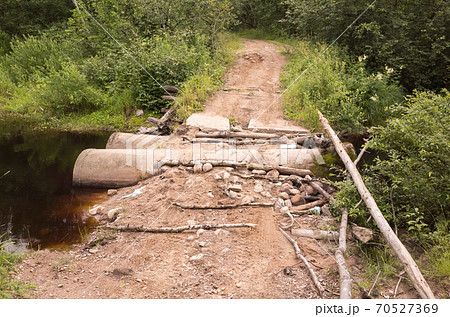 Empty rural road with damaged bridge 70527369