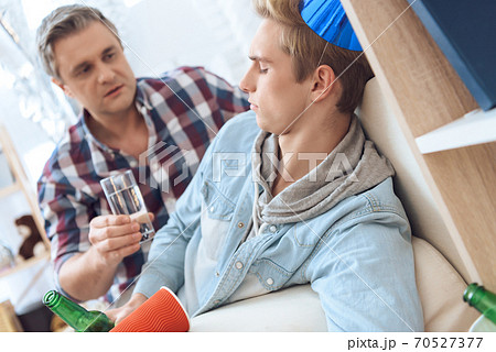 Dad gives his son a glass of water.  70527377