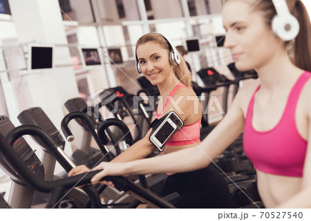 Mother and daughter running on treadmill at gym. Mother and daughter running on treadmill at gym. 70527540