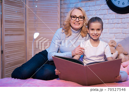 Grandmother and granddaughter looking at camera. 70527546