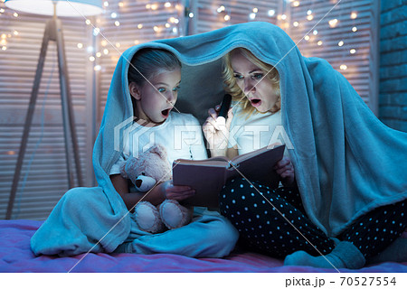 Grandmother and granddaughter are reading book. 70527554
