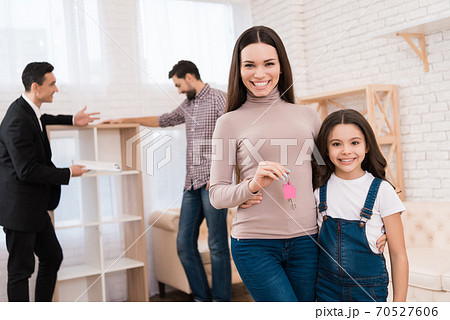 Mom hugs daughter and holds key to new apartment. Mom hugs daughter and holds key to new apartment. 70527606
