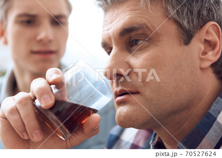 man with a glass of alcohol in his hand.  70527624