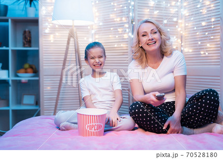 Grandmother and granddaughter watch TV. Grandmother and granddaughter watch TV. 70528180