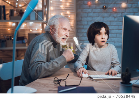 Grandfather supports grandson who plays games. 70528448