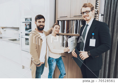 A man in a suit stands with a planchette in hands. 70528561