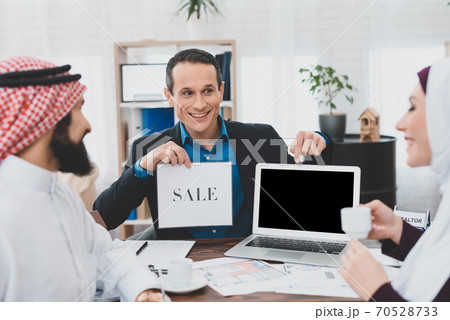 Cheery realtor shows photos of house for sale. 70528733