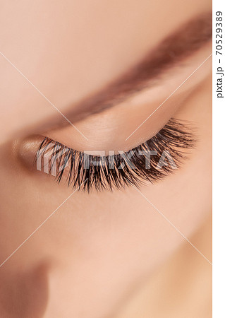 Eyelash Extension Procedure. Woman Eye with Long Eyelashes. Close up, selective focus. Eyelash Extension Procedure. Woman Eye with Long Eyelashes. Close up, selective focus. 70529389