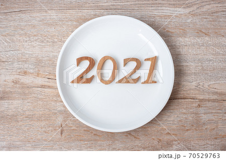 2021 Happy New Year and New You with white plate on wood background. Goals, Healthy, Healthcare, Resolution, Time to New Start, sport, fitness and dieting concept 2021 Happy New Year and New You with white plate on wood background. Goals, Healthy, Healthcare, Resolution, Time to New Start, sport, fitness and dieting concept 70529763