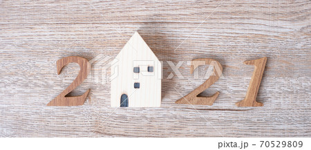 2021 Happy New Year with house model on table wooden background. Banking, real estate, investment, financial, savings and New Year Resolution concepts 70529809