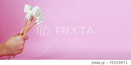 bouquet of marshmallows on pink background. child's hand holding a bouquet of sweets. banner 70529971