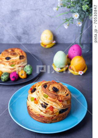Craffin (Cruffin) with raisins, nuts and candied fruits. Easter Bread Kulich and painted eggs. Easter Holiday. Close-up. 70530847