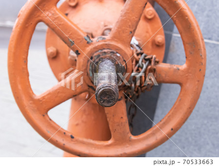 large iron valve wrapped in a close-up chain to adjust the pressure in the system 70533663