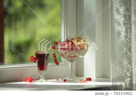 Red and white currant fruits and juice in glass on the window Red and white currant fruits and juice in glass on the window 70533902