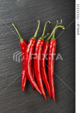 Red chili pepper on a black slate board. 70535315