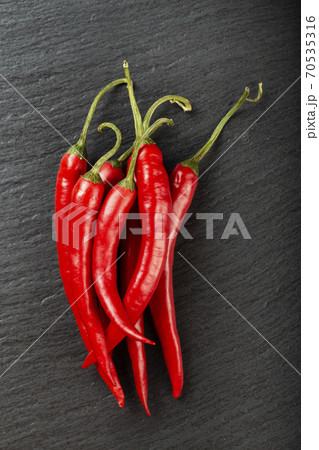 Red chili pepper on a black slate board. 70535316
