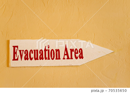 Warning sign Evacuation area on a yellow wall. 70535650