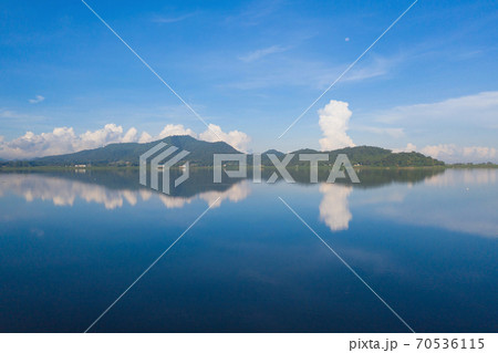 Aerial view of Bang Pra Reservoir dam. National park with reflection of river lake, mountain valley hills at noon and blue sky in Sri Racha, Chonburi, Thailand in travel trip. Natural landscape. Aerial view of Bang Pra Reservoir dam. National park with reflection of river lake, mountain valley hills at noon and blue sky in Sri Racha, Chonburi, Thailand in travel trip. Natural landscape. 70536115