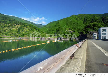 夏の奥多摩湖　堤頂の道路と湖面と南岸の山々 70536867