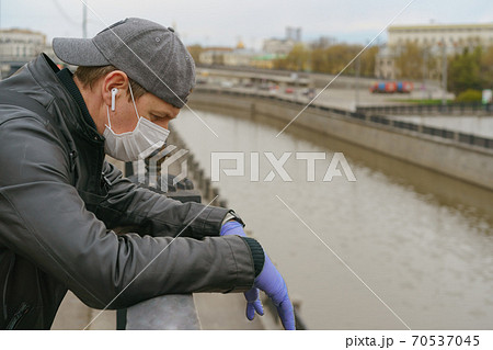 Man wearing protective mask outdoors. Coronavirus pandemic time. Man wearing protective mask outdoors. Coronavirus pandemic time. 70537045
