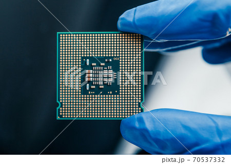 Close-up view on a new semiconductor microchip in gloved hand of computer scientist. Modern technology and hardware development 70537332