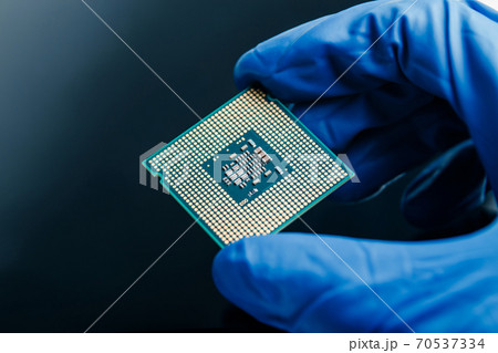 Close-up view on a new semiconductor microchip in gloved hand of computer scientist. Modern technology and hardware development Close-up view on a new semiconductor microchip in gloved hand of computer scientist. Modern technology and hardware development 70537334