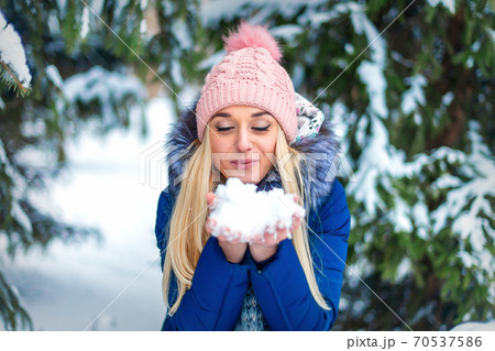 Woman blowing on the snow Woman blowing on the snow 70537586