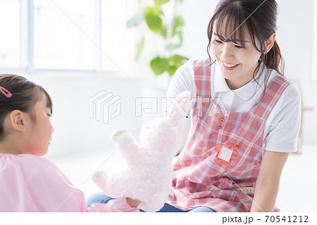 ぬいぐるみで遊ぶ女の子と保育士 70541212
