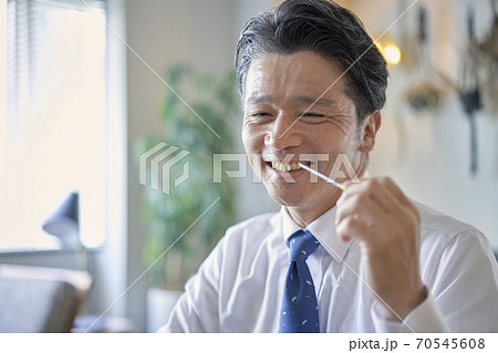 ビジネス　お菓子を食べる中年男性　 70545608