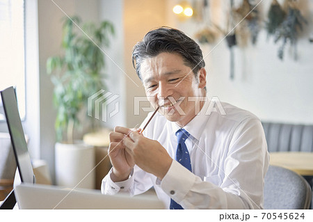 ビジネス　お菓子を食べる中年男性　 70545624