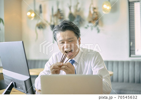ビジネス　お菓子を食べる中年男性　 70545632