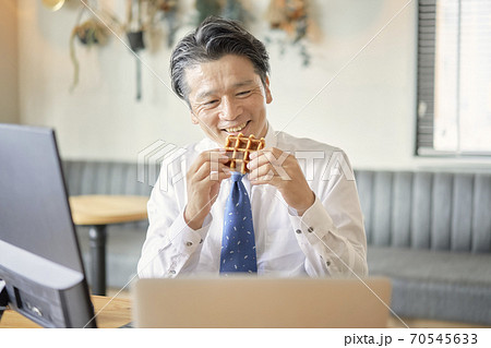 ビジネス　お菓子を食べる中年男性　 70545633