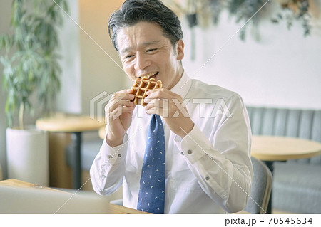 ビジネス　お菓子を食べる中年男性　 70545634