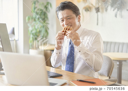 ビジネス　お菓子を食べる中年男性　 70545636
