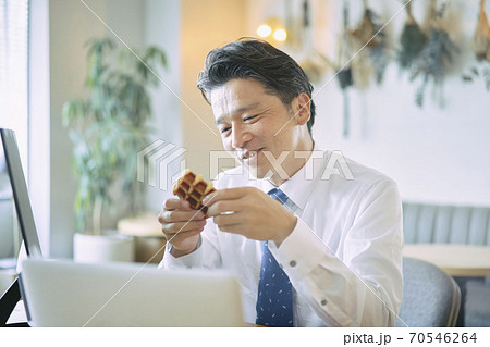 ビジネス　お菓子を食べる中年男性　 70546264