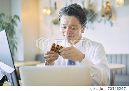 ビジネス　お菓子を食べる中年男性　 70546267