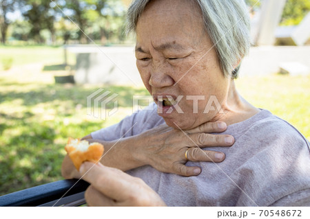 Asian senior woman suffers from choke and cough,clogged up food,elderly people choking during feeding,food might stuck in the throat and suffocate ,health problem, asphyxia,suffocation concept 70548672