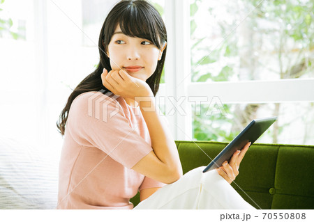 タブレットを使う笑顔の女性 タブレットを使う笑顔の女性 70550808