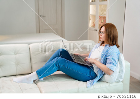 woman works lying on couch with computer. epidemic woman works lying on couch with computer. epidemic 70551116