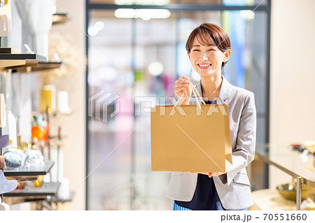 紙袋を渡す女性店員 撮影協力:g GIFT AND LIFESTYLE 紙袋を渡す女性店員 撮影協力:g GIFT AND LIFESTYLE 70551660